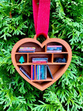 Heart-shaped ornament with books and a tree on a green leaf background